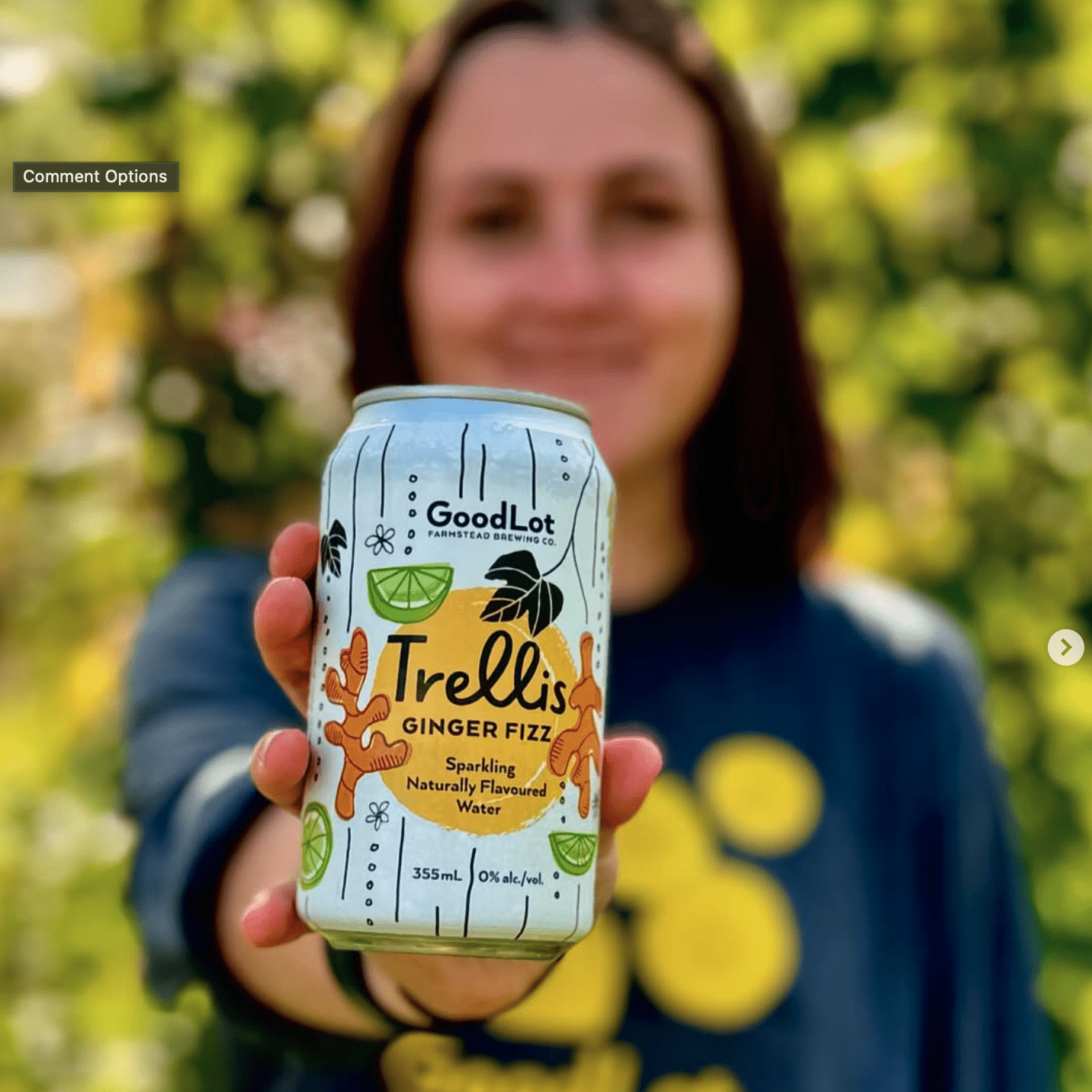 girl holding Trellis Ginger Fizz from Goodlot out to camera